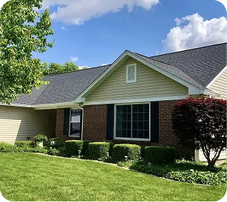 Suburban house with manicured lawn and shrubs.